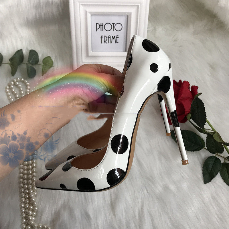 Tacones altos de charol blanco con lunares negros