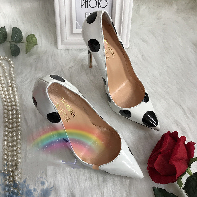 Tacones altos de charol blanco con lunares negros