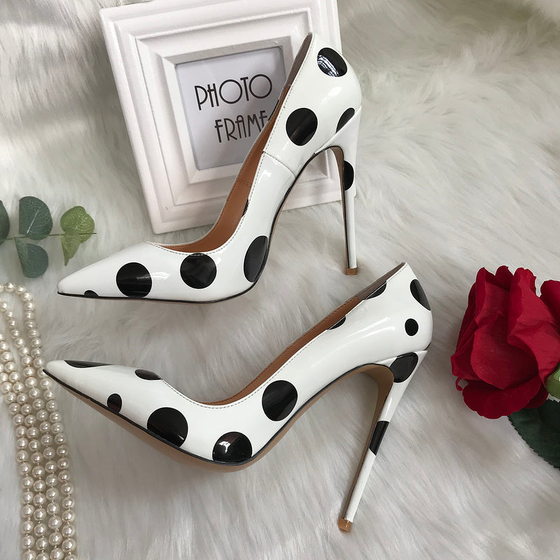 Tacones altos de charol blanco con lunares negros